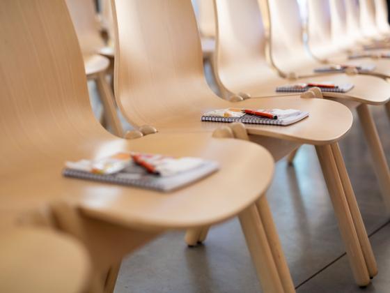 chairs with notebooks and pens on them